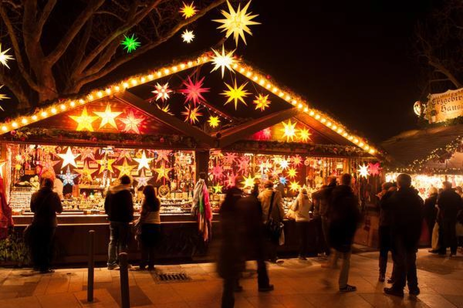 GTS - Reiseservice - Menschen schlendern über einen lebhaften Nachtmarkt, der von leuchtenden mährischen Laternen erhellt wird.